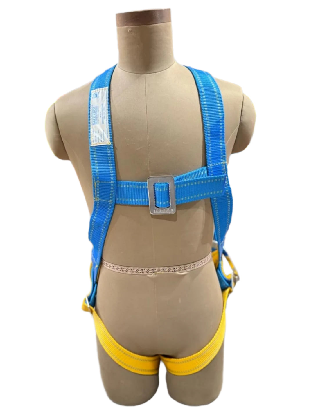 Mannequin wearing a blue safety harness with a yellow waistband in a workshop setting.